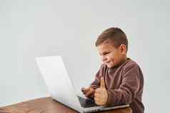 孩子男孩研究在线移动PC显示拇指微笑在线教育电子学习孩子采取在线课程移动PC