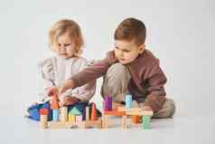 孩子们哥哥妹妹微笑有趣的玩彩色的砖玩具白色背景孩子们微笑有趣的