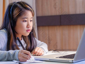 亚洲女孩研究在线笔记本电脑孩子穿耳机打字键盘笔记本<strong>学习</strong>互联网教训检疫学生<strong>学习</strong>互联网在线类学校新冠病毒