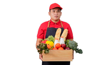 杂货店交付快递男人。红色的统一的杂货店盒子食物新鲜的水果蔬菜交付男人。红色的统一的围裙处理木箱食物水果蔬菜孤立的剪裁路径