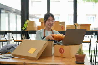 年轻的开始小业务老板包装纸板盒子工作场所自由女人卖方准备包裹盒子产品交付客户在线销售电子商务航运概念