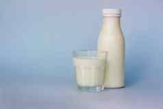 玻璃瓶白色牛奶突出显示蓝色的背景特写镜头