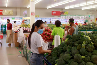 亚洲女人长头发穿保护脸面具<strong>超市</strong>部门商店女杂货店买<strong>水果</strong>正常的科维德家庭概念