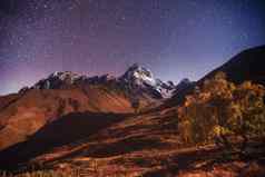 神奇的布满星星的天空秋天景观白雪覆盖的山峰