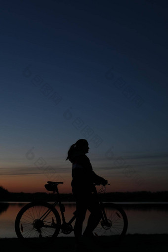 轮廓女人山自行车色彩斑斓的蓝色的天空日落背景活跃的在户外生活方式