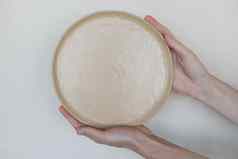 手持有陶瓷盘子孤立的白色背景极简主义集手工制作的陶瓷餐具陶器