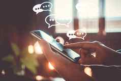 人手智能手机打字聊天文本消息闲谈，聊天图标流行社会媒体市场技术概念