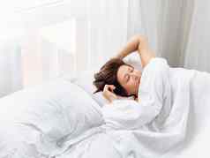 高加索人女人睡觉床上健康的睡眠白色床上亚麻早....舒适的首页