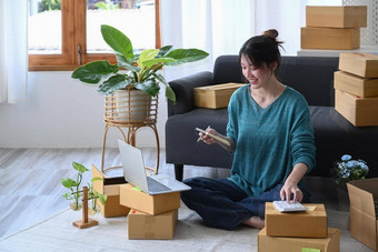 年轻的亚洲女人计算器准备产品交付客户锻造市场营销概念