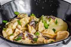俄罗斯食物水饺肉饺子蘑菇酱汁被捣成糊状的土豆黑色的碗特写镜头