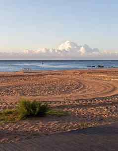平静早....空海滩车轮胎打印沙子海云背景