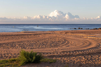 平静早....空海滩<strong>车轮</strong>胎打<strong>印</strong>沙子海云背景