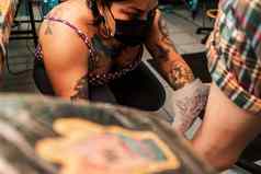 拉丁美洲纹身艺术家把草图纹身客户的腿工作室马那瓜