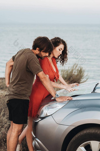 快乐年轻的夫妇男人。女人检查地图罩车计划<strong>路</strong>旅行海边