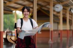 年轻的旅行者女人地图规划旅行火车站夏天旅行生活方式概念