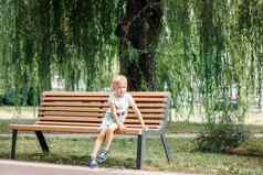 小孩子戏剧公园孩子坐着公园板凳上快乐家庭童年概念健康的婴儿在户外