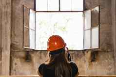 女人橙色头盔头站前面开放窗口锅炉建筑