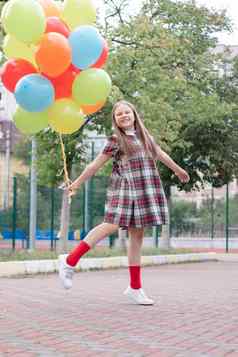 十几岁的女孩色彩斑斓的氦空气气球有趣的在户外渐变聚会，派对享受夏天