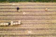 空中视图无人机拖拉机收集包有收获小麦场