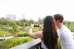 夫妇采取照片城市景观移动公园日落