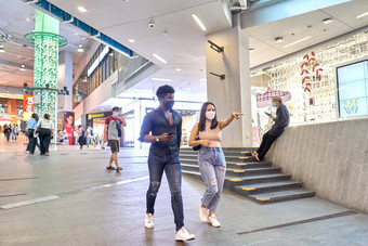 亚洲女人穿面具指出之前走朋友购物中心