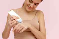 手皮肤护理年轻的高加索人女人享受软滋润皮肤挤压手奶油
