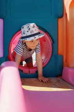 男孩他粉红色的隧道操场上孩子培训发展中物理技能