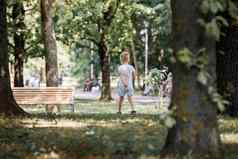 可爱的男孩走城市公园美丽的夏天阳光明媚的一天大橡木树