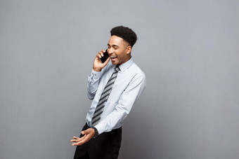 业务概念快乐的专业非洲美国商人快乐会说话的移动电话客户端