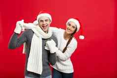 圣诞节概念快乐年轻的夫妇sweatesr庆祝圣诞节玩跳舞