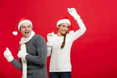 圣诞节概念快乐年轻的夫妇sweatesr庆祝圣诞节玩跳舞