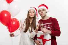 圣诞节概念年轻的女朋友持有气球香槟玩庆祝的男朋友圣诞节一天