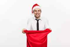 圣诞节概念英俊的业务男人。庆祝快乐圣诞节快乐一年穿圣诞老人他圣诞老人红色的大袋