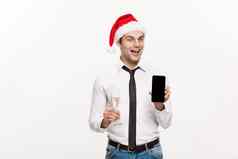 圣诞节概念英俊的业务男人。会说话的电话持有玻璃champange庆祝圣诞一年