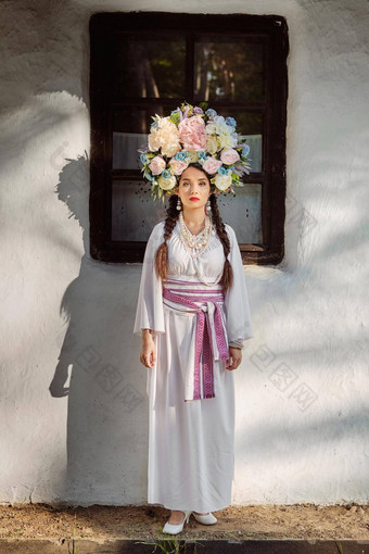 浅黑肤色的女人女孩白色乌克兰真实的国家服装花环花摆姿势白色小屋特写镜头
