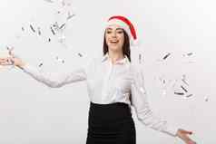 圣诞节庆祝活动概念年轻的业务女人扔五彩纸屑庆祝圣诞节一天孤立的白色背景
