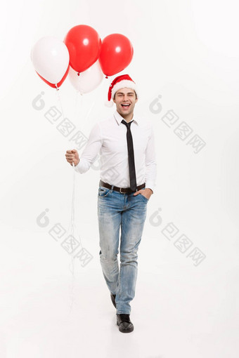 圣诞节概念英俊的快乐业务男人。<strong>走红</strong>色的气球庆祝快乐圣诞节快乐一年穿圣诞老人他