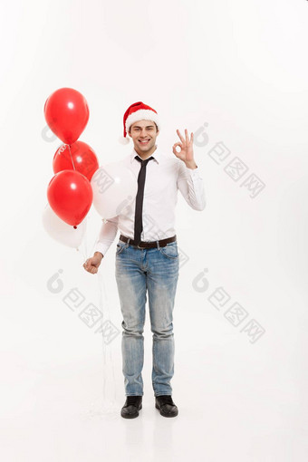 圣诞节概念英俊的快乐业务男人。<strong>走红</strong>色的气球庆祝快乐圣诞节快乐一年穿圣诞老人他
