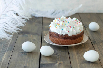 白色复活节蛋糕彩色的甜蜜的洒鸡蛋羽毛木背景快乐复活节概念