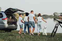 成员家庭旅行小货车车野餐日落湖妈妈。父亲十几岁的孩子们宠物西高地白色梗狗