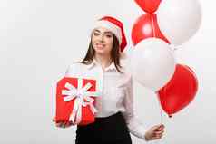 圣诞节概念年轻的快乐高加索人业务女人圣诞老人他持有礼物盒子气球复制空间一边
