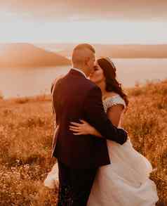 爱的夫妇婚礼新婚夫妇拥抱接吻夏天场山河