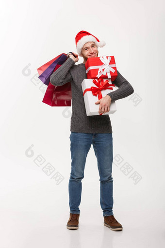 圣诞节概念有吸引力的年轻的高加索人男人。享受购物持有很多礼物圣诞节一天
