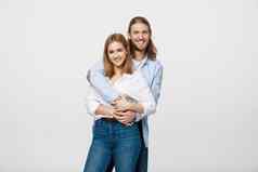 肖像快乐的年轻的夫妇站拥抱孤立的白色背景