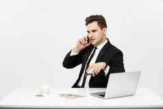 业务概念肖像年轻的成功的商人工作明亮的办公室移动PC会说话的电话