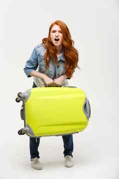 旅行生活方式概念年轻的女人遭受回来疼痛提升重手提箱孤立的黄色的背景