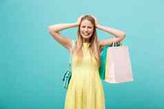 买东西出售概念美丽的不开心年轻的女人黄色的优雅的衣服购物袋