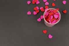 红色的粉红色的心糖果透明的杯黑暗背景爱情人节概念