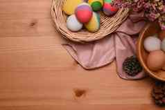 色彩斑斓的复活节鸡蛋柳条篮子木背景复制空间