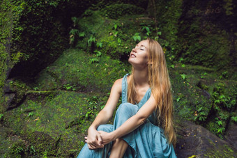 年轻的女人旅行者巴厘岛的花园杂草丛生的莫斯旅行巴厘岛概念